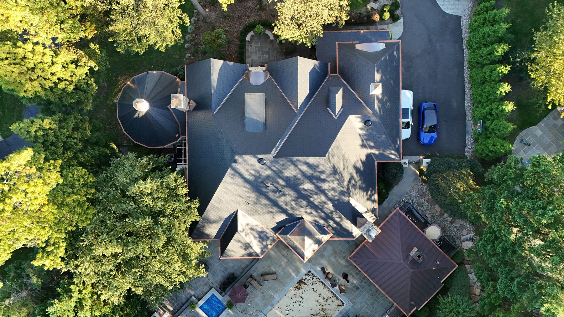 Top-down view of black slate roof with copper drip edge and turret