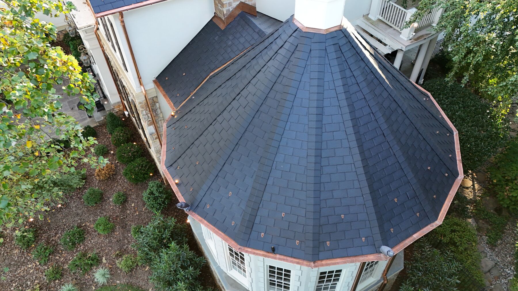 Round turret in black synthetic slate with copper drip edge