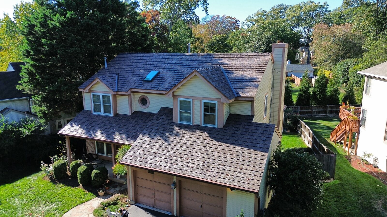Aerial view of a colonial home with a cedar-tone Brava synthetic shake roof and dormers