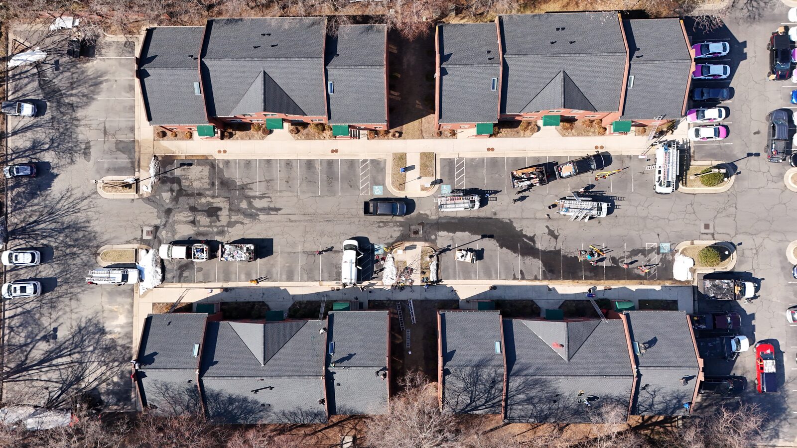 Top-down aerial of the same townhome community with new roofs complete